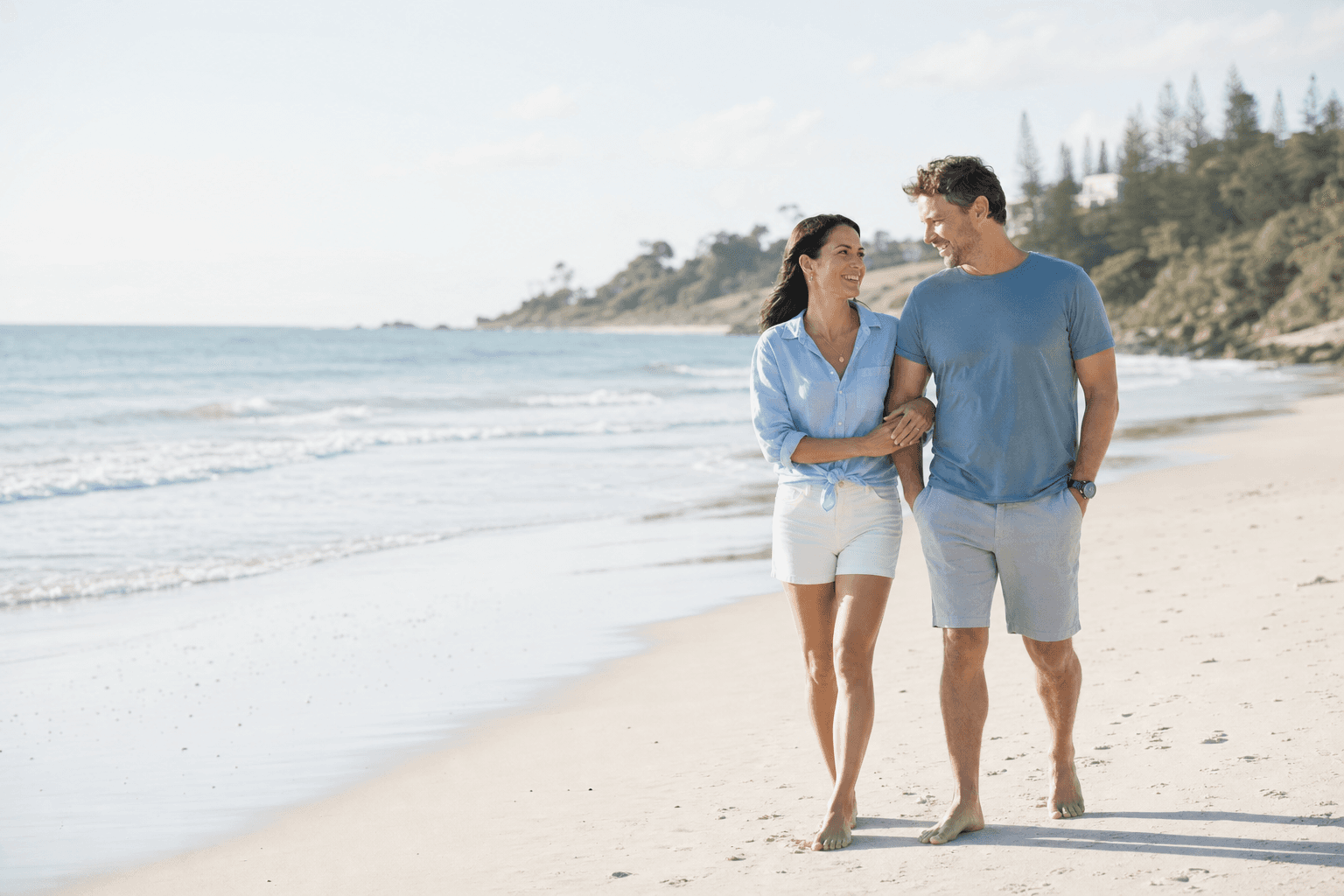 Australian couple walking together on the coast while planning retirement