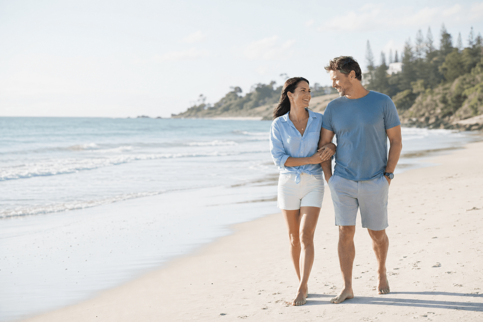 Australian couple walking together on the coast while planning retirement